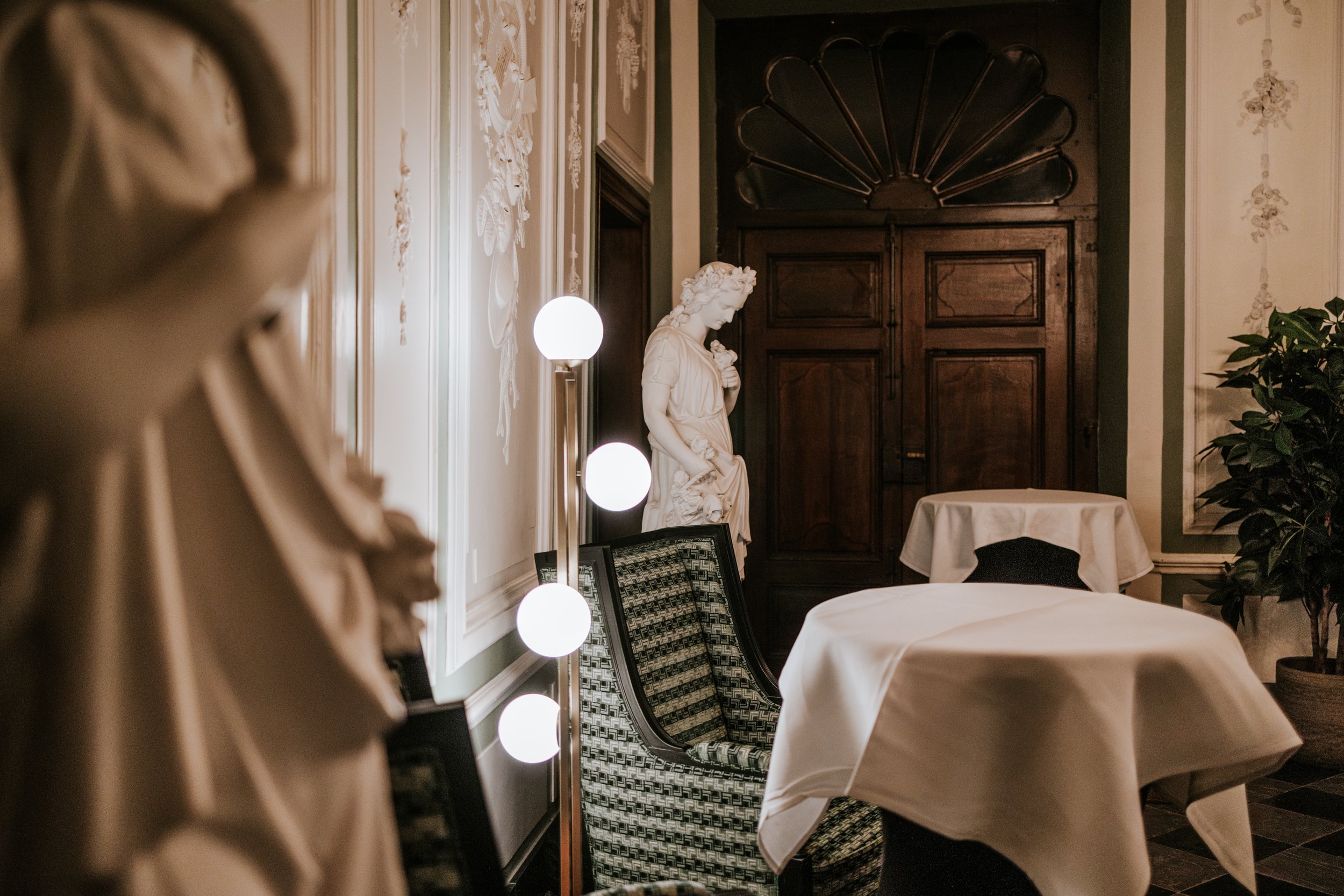 Classical sculpture and contemporary lighting in a Chateau de Looz salon