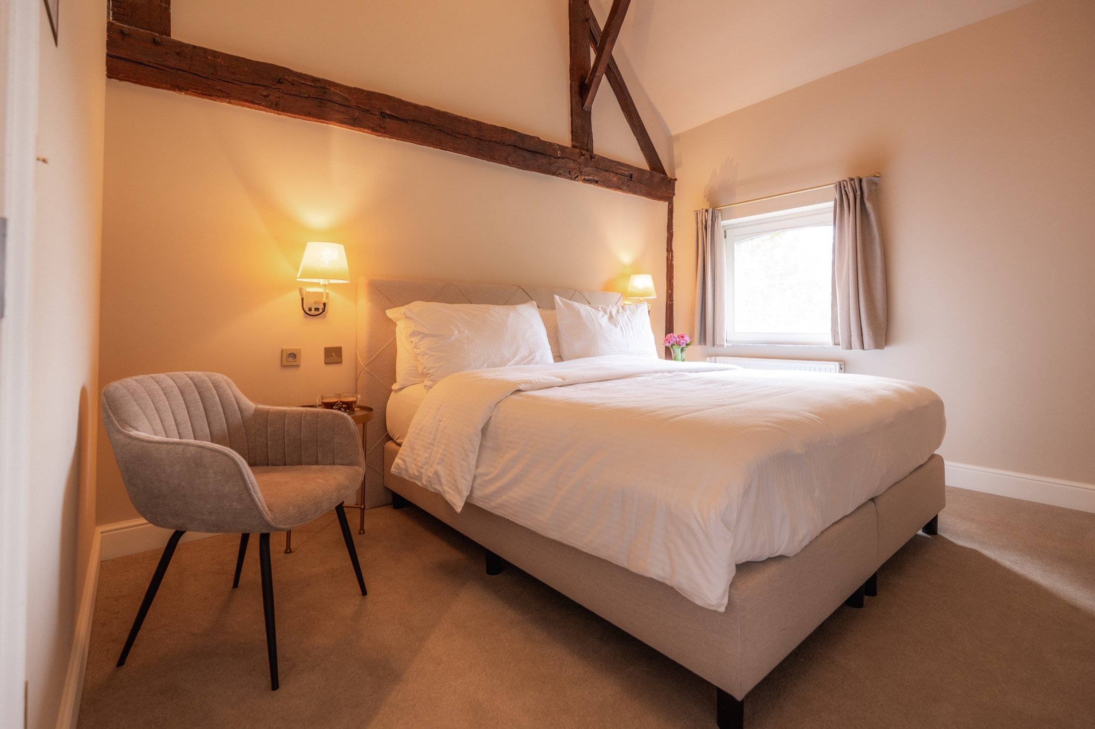 Guest room beneath the historic roof structure at Chateau de Looz