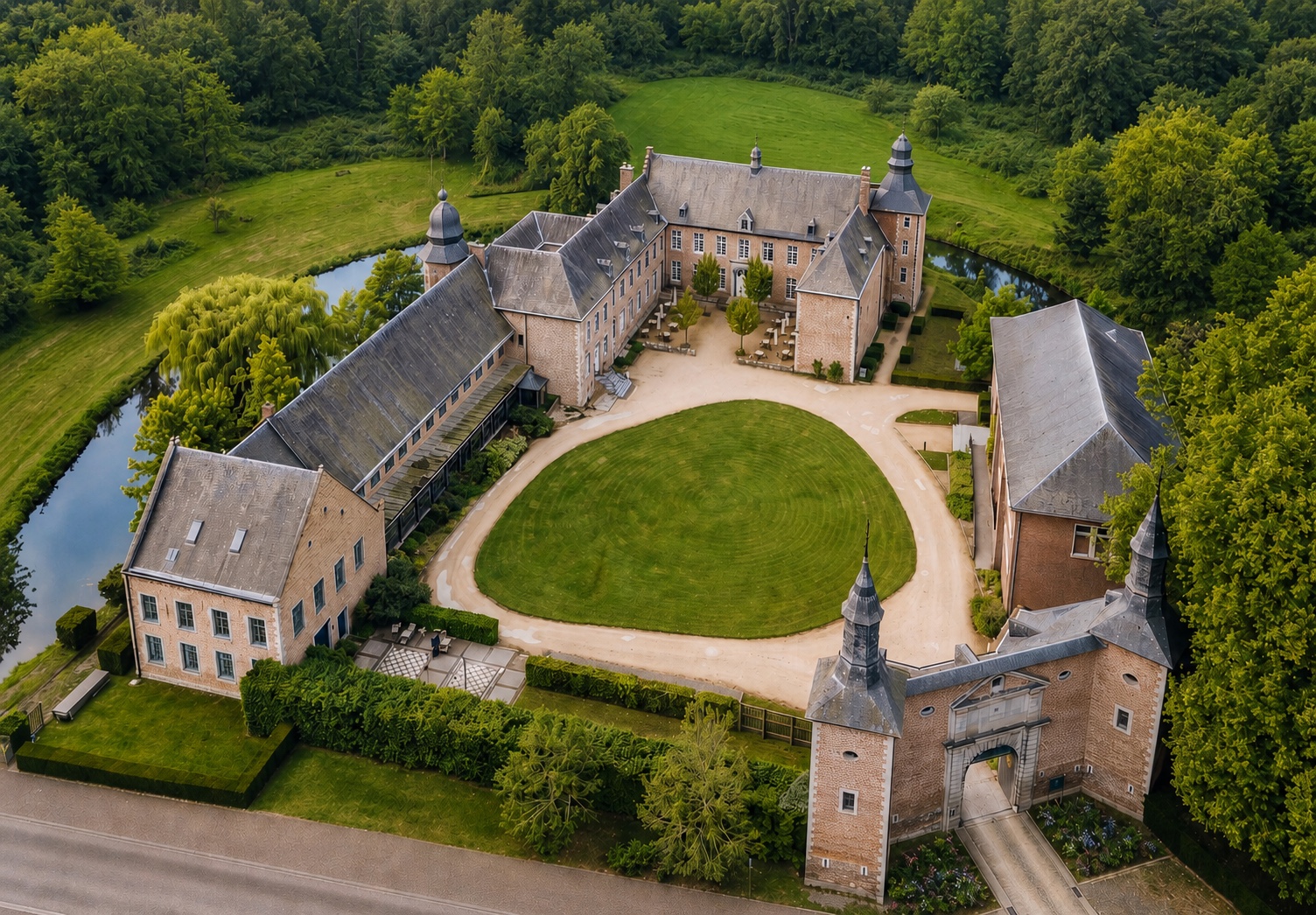 Aerial view of Château de Looz surrounded by its moat, lawns and mature parkland